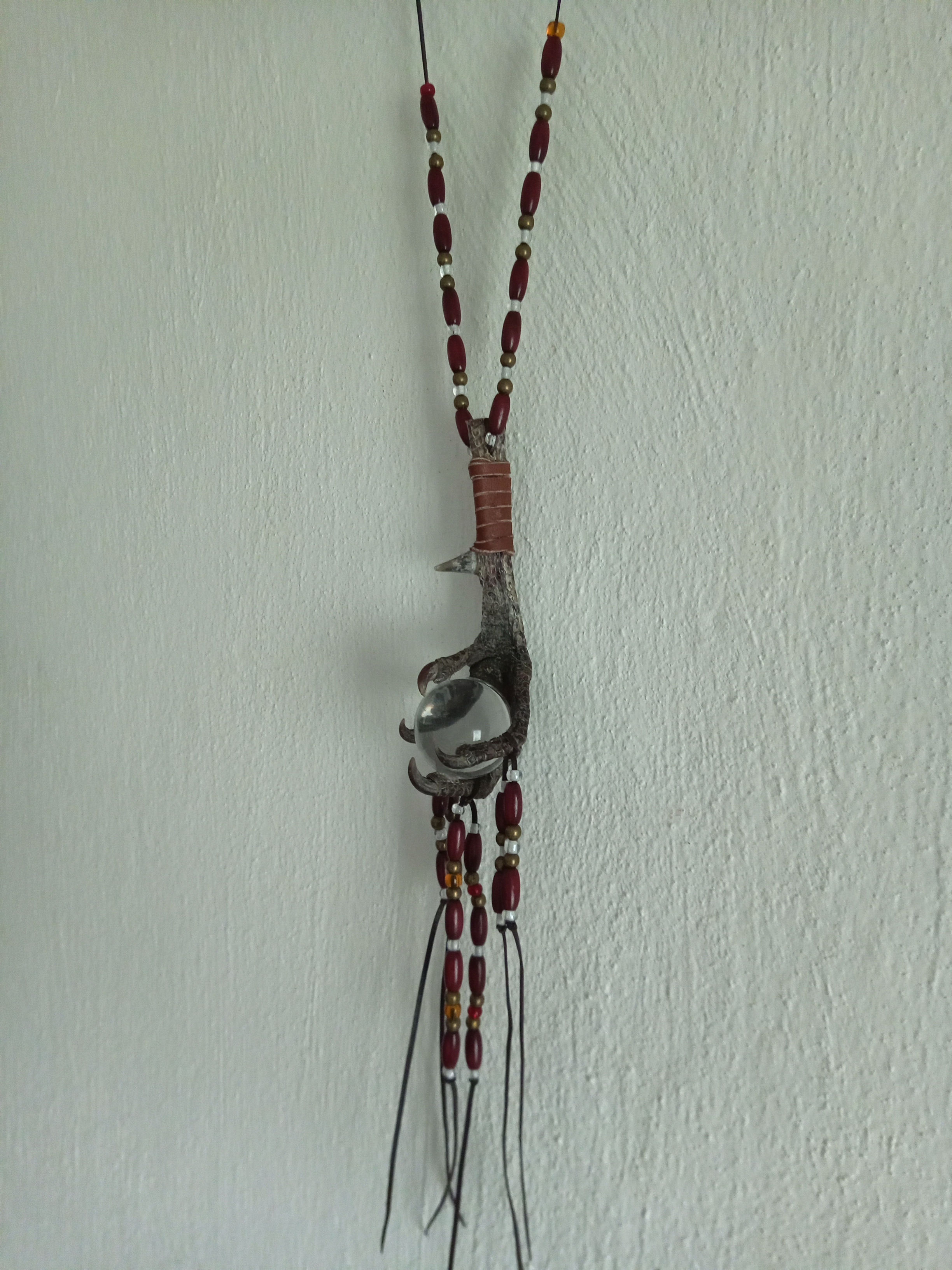 amulet s ptačí nohou a skleněnou koulí